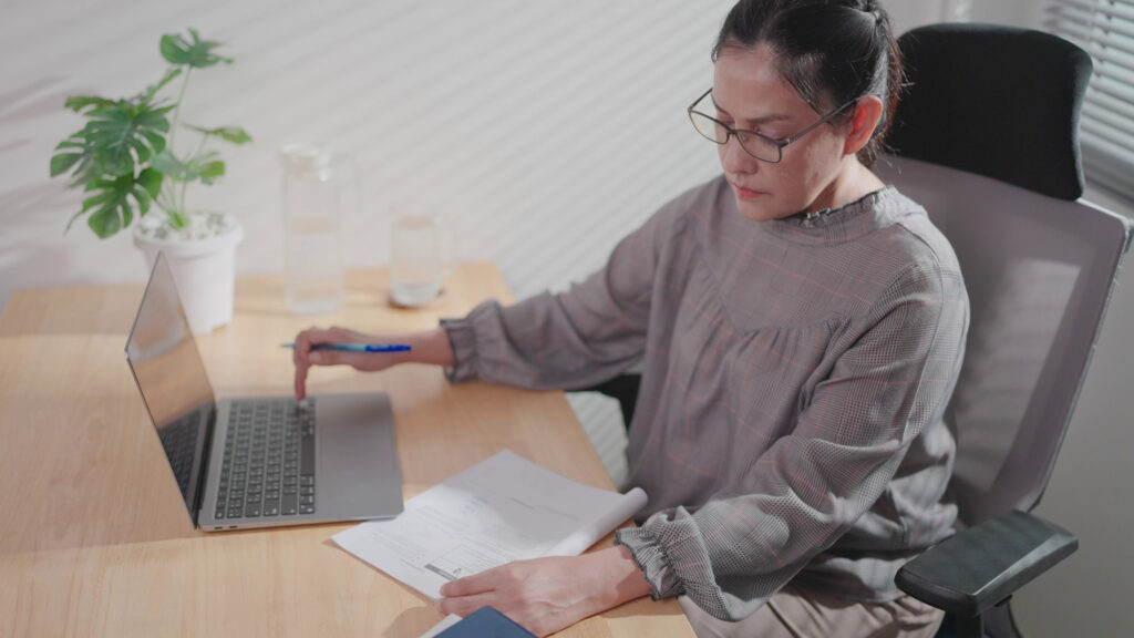 Investor reviewing losses on a chart with calculator, representing tax loss harvesting strategy